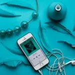 iPhone with EarPods beside feathers